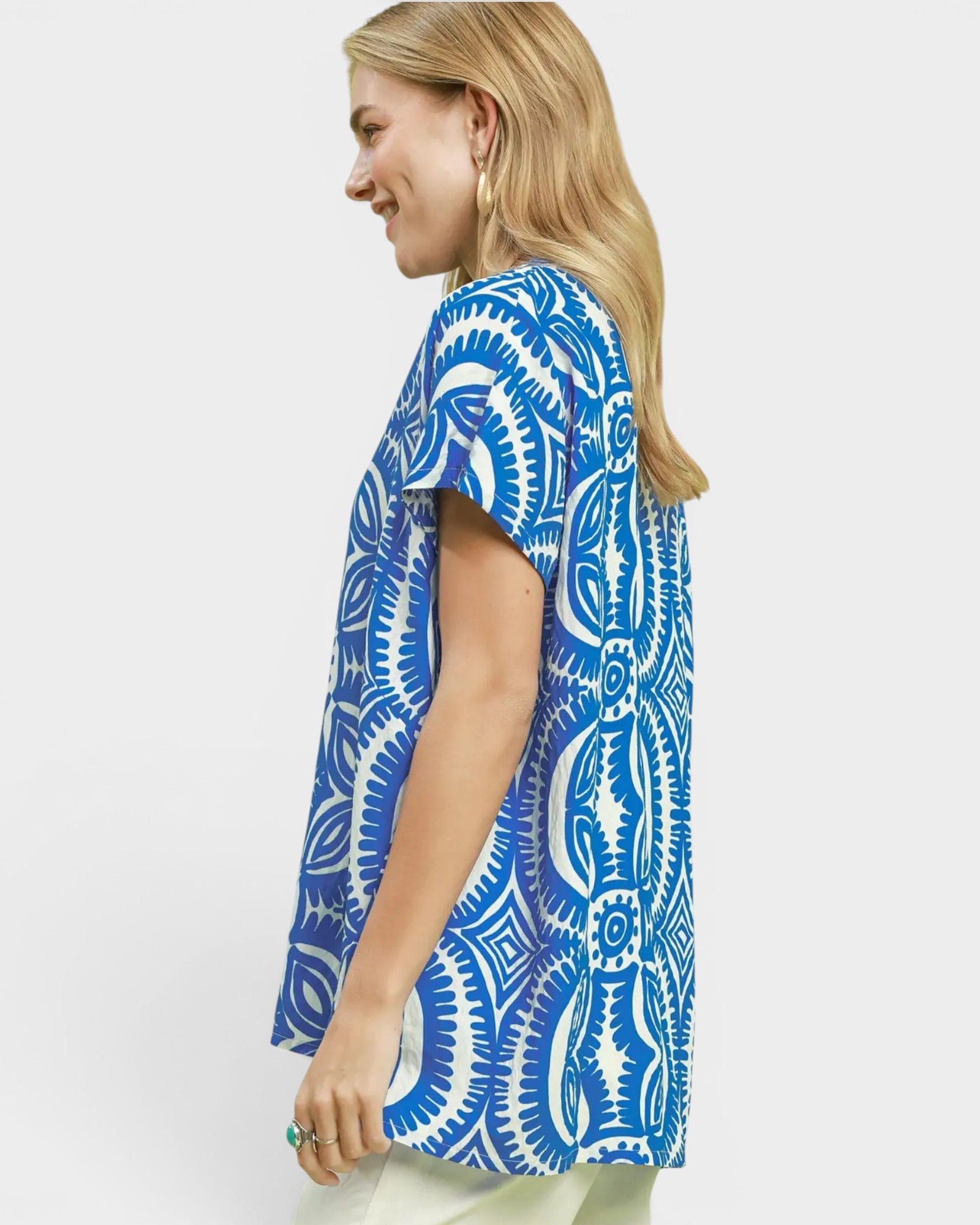 Woman wearing a blue and white patterned shirt on a plain background