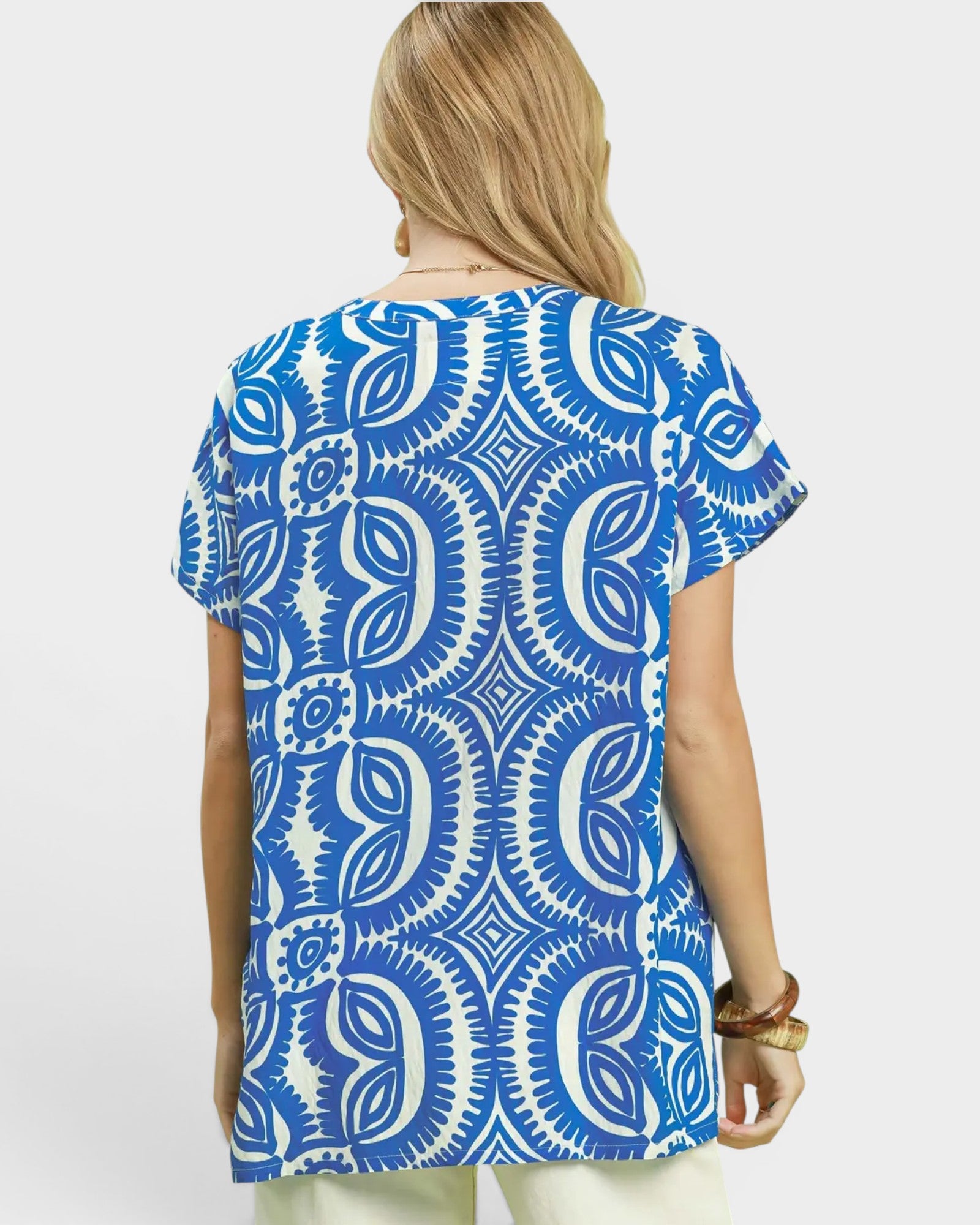 Woman wearing a blue and white patterned shirt on a light gray background