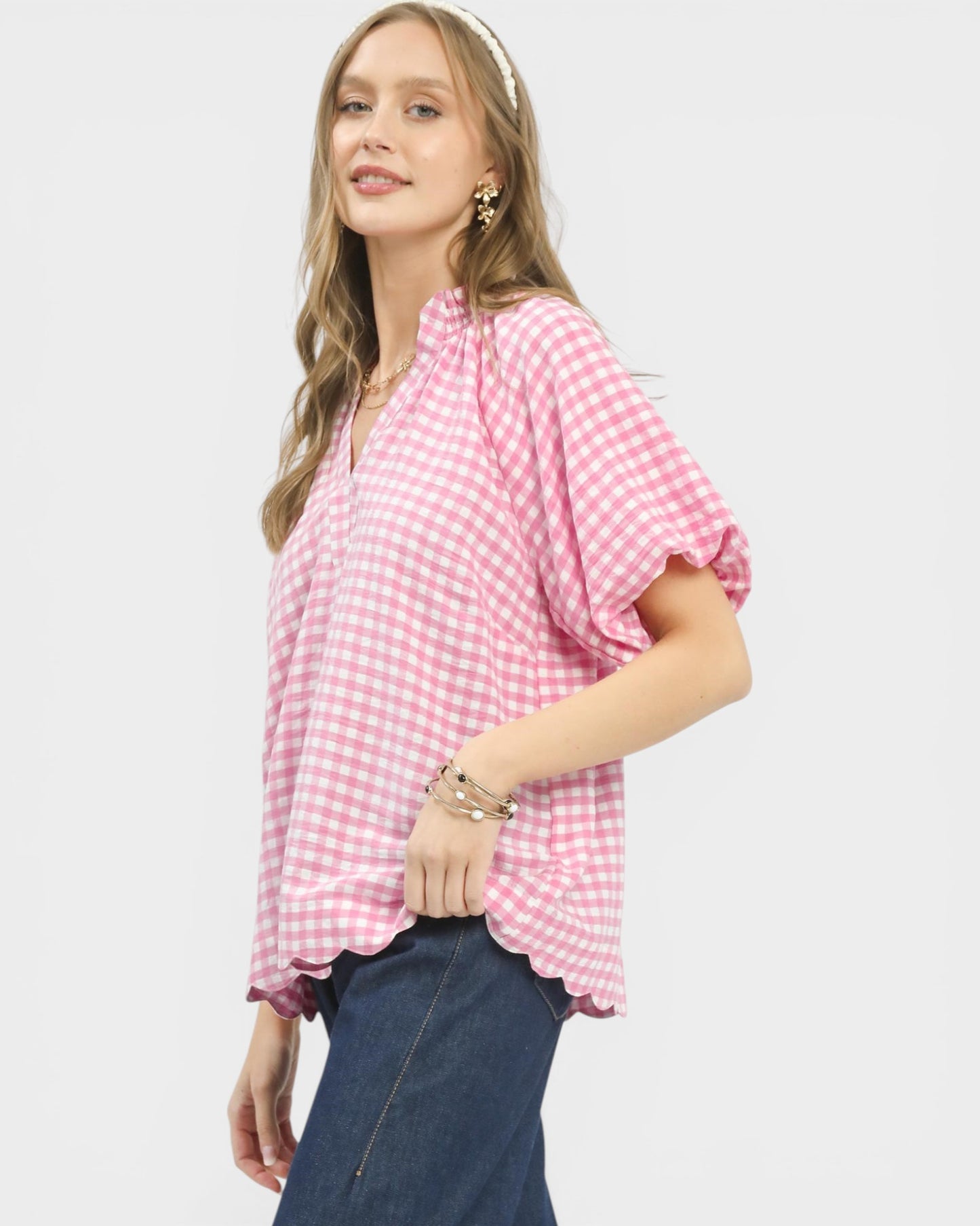 Woman wearing a pink checkered top on a white background
