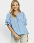 Woman wearing a blue and white checkered blouse on a light gray background