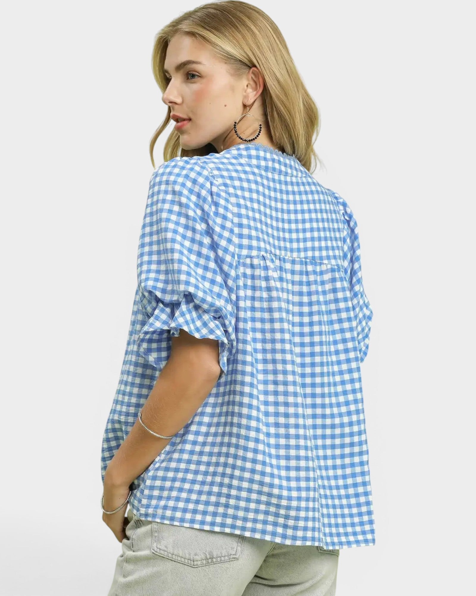 Woman wearing a blue and white checkered shirt on a white background