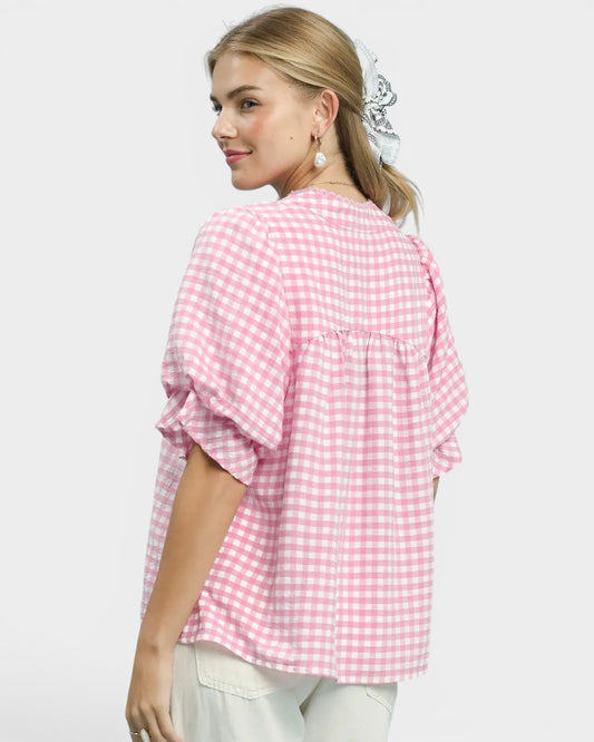 Woman wearing a pink checkered blouse on a white background