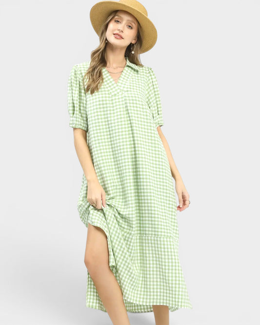 Woman wearing a green checkered dress and straw hat on a white background