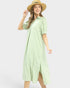 Woman wearing a green checkered dress and straw hat on a white background