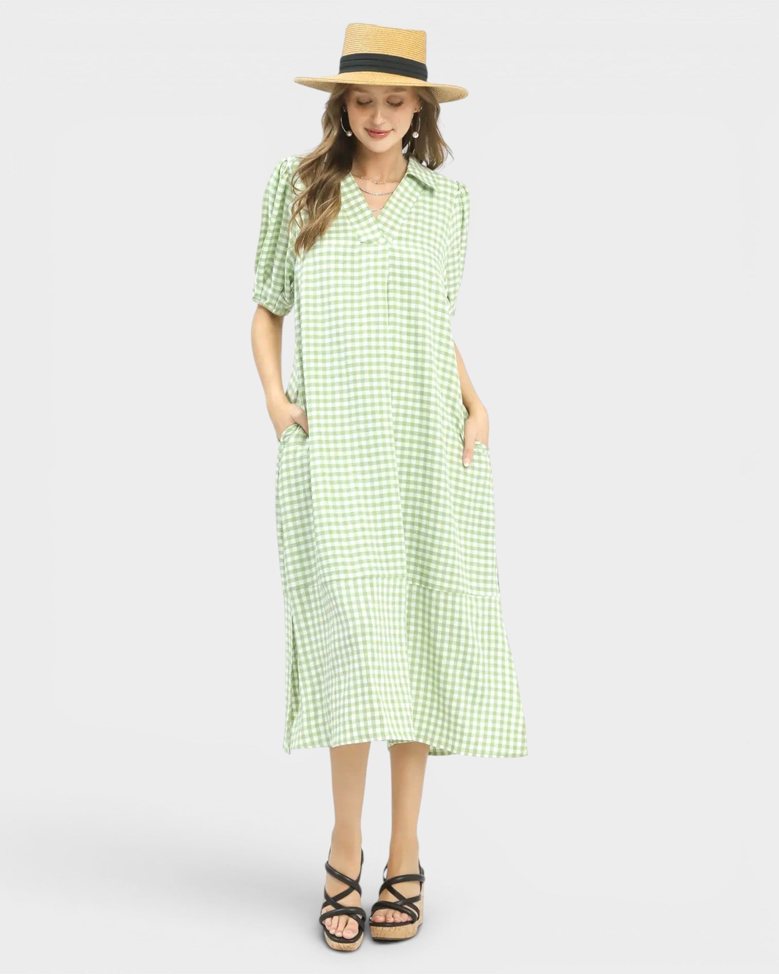 Woman wearing a green checkered dress and straw hat on a white background