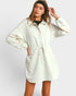 Woman wearing a light gray hoodie dress against a white background
