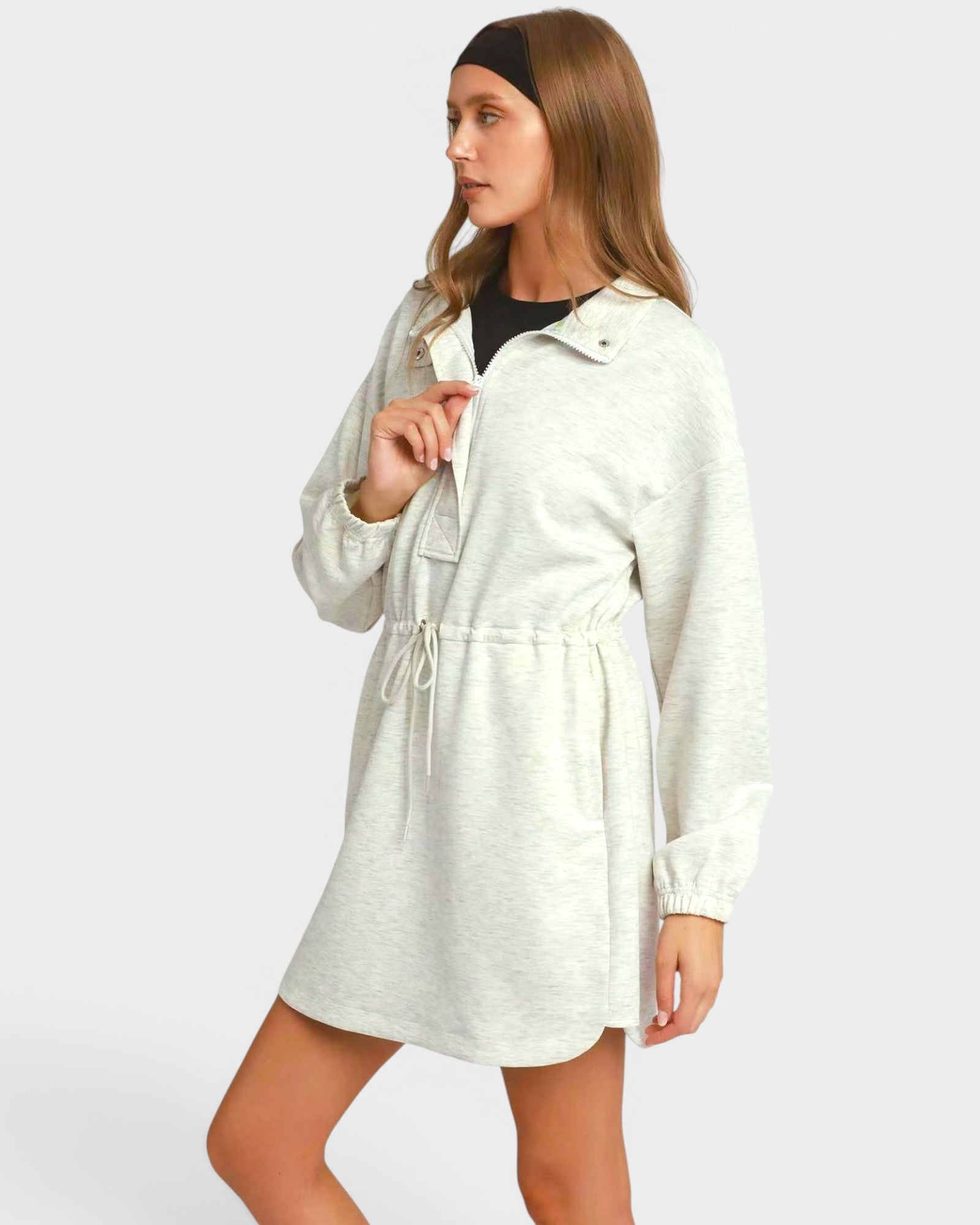 Woman wearing a light gray dress with a white background