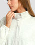 Close-up of a person wearing a light gray zip-up hoodie against a neutral background