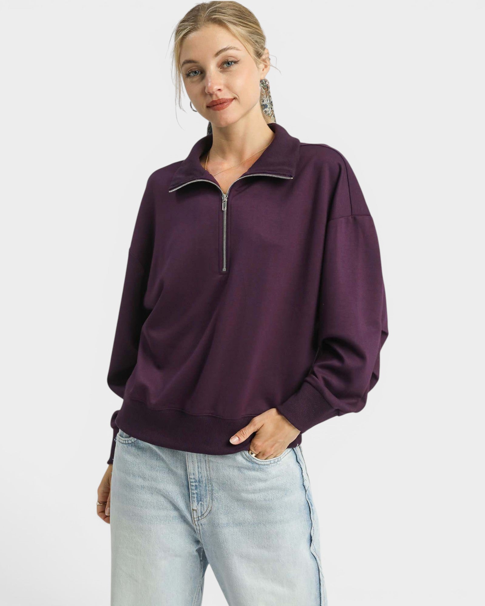 Woman wearing a purple pullover with a zipper on a white background