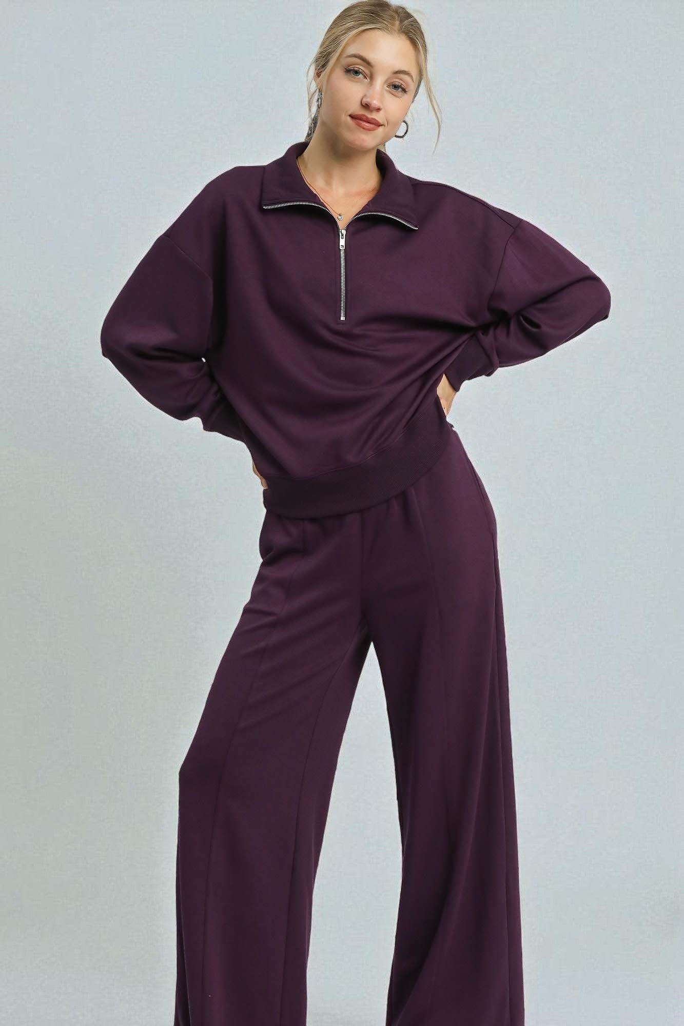 Person wearing a purple outfit on a light gray background