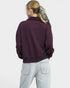 Person wearing a purple sweatshirt and light blue jeans on a white background