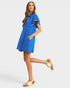 Woman wearing a blue dress with white trim on a light gray background