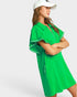 Woman wearing a green dress with white trim on a white background