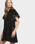Woman wearing a black dress with white trim on a white background
