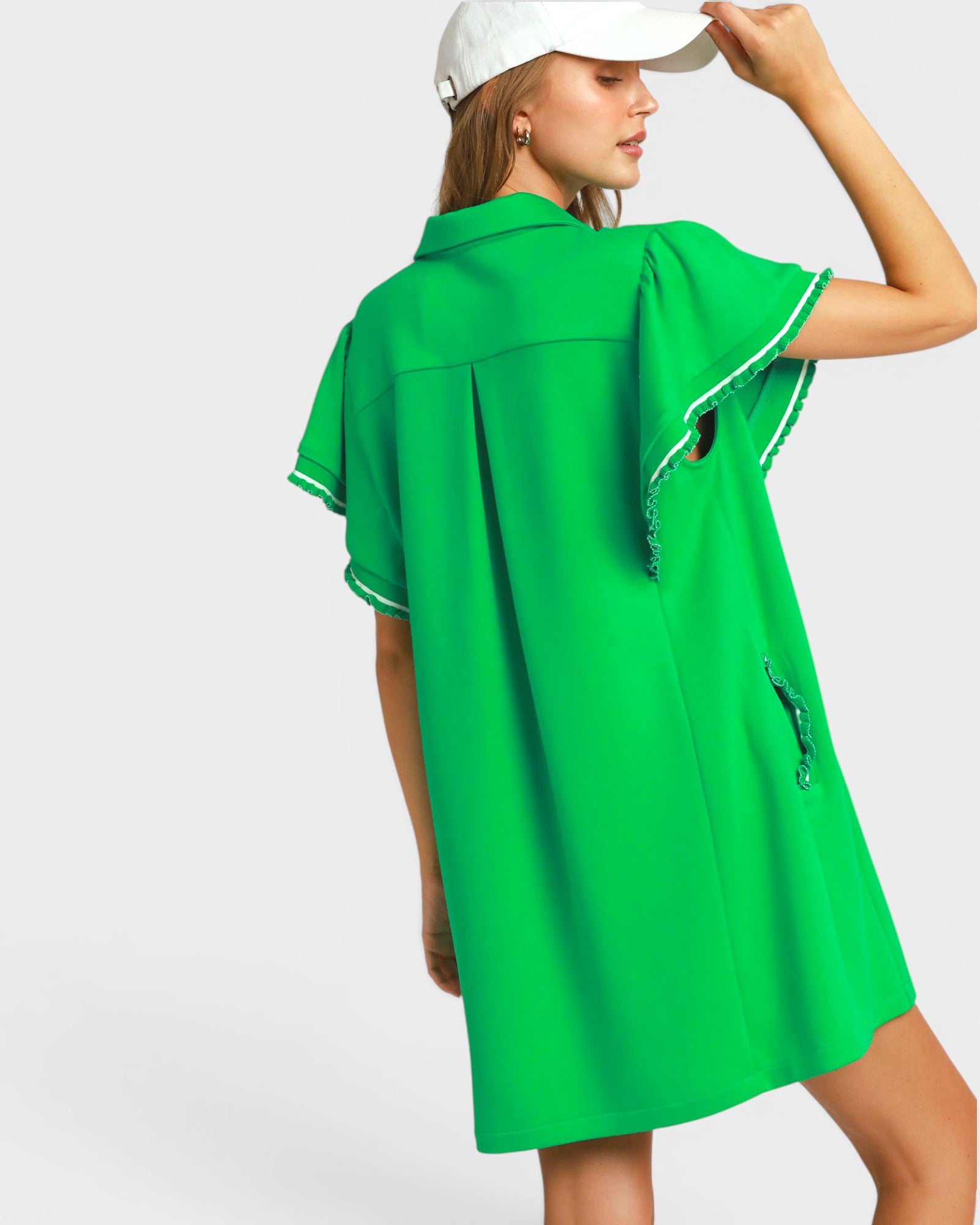 Woman wearing a green dress with white trim on a white background