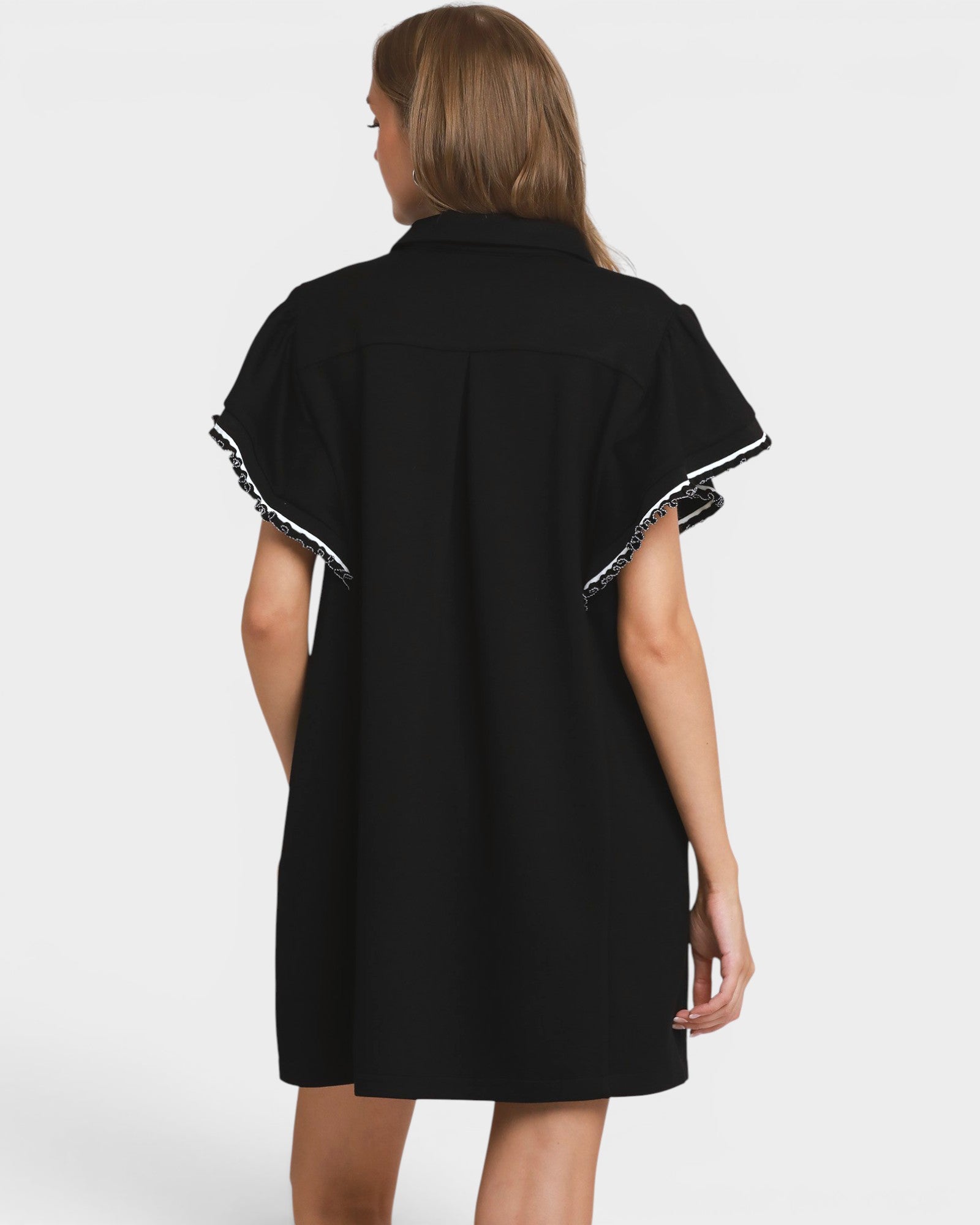 Black dress with white trim on a plain background