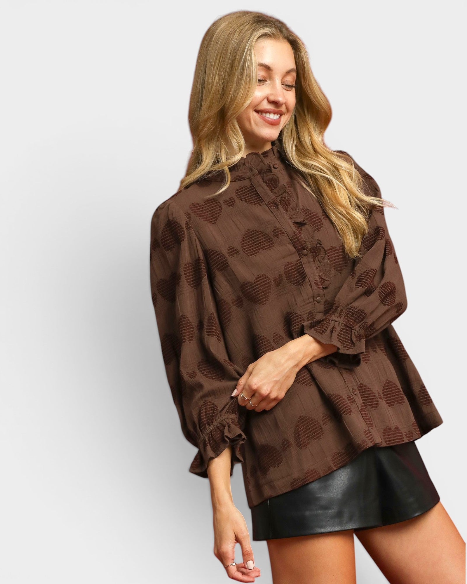 Woman wearing a brown patterned blouse and black skirt on a white background