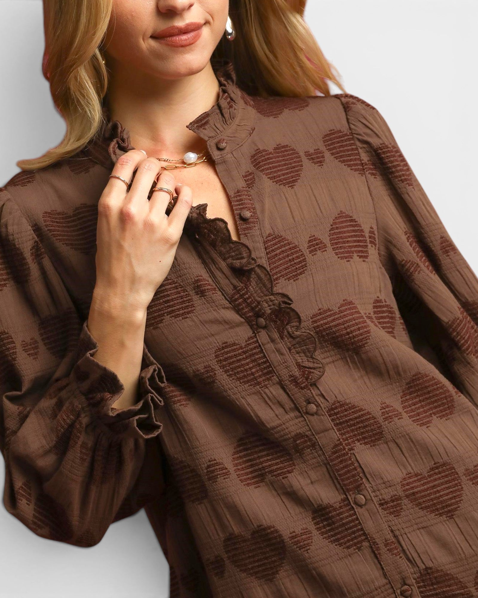 Woman wearing a brown patterned blouse with a blurred background