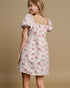 Woman wearing a floral dress with puff sleeves on a beige background