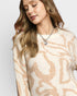 Woman wearing a patterned sweater with a neutral background