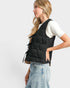 Woman wearing a black quilted vest on a white background