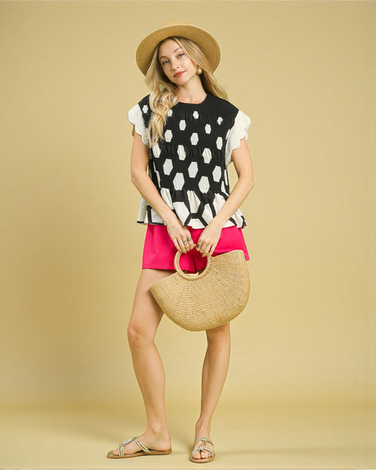 Woman holding a straw bag against a beige background