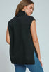 Woman wearing a black sleeveless sweater over a blue top against a light gray background