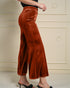 Brown velvet pants worn by a person on a neutral background
