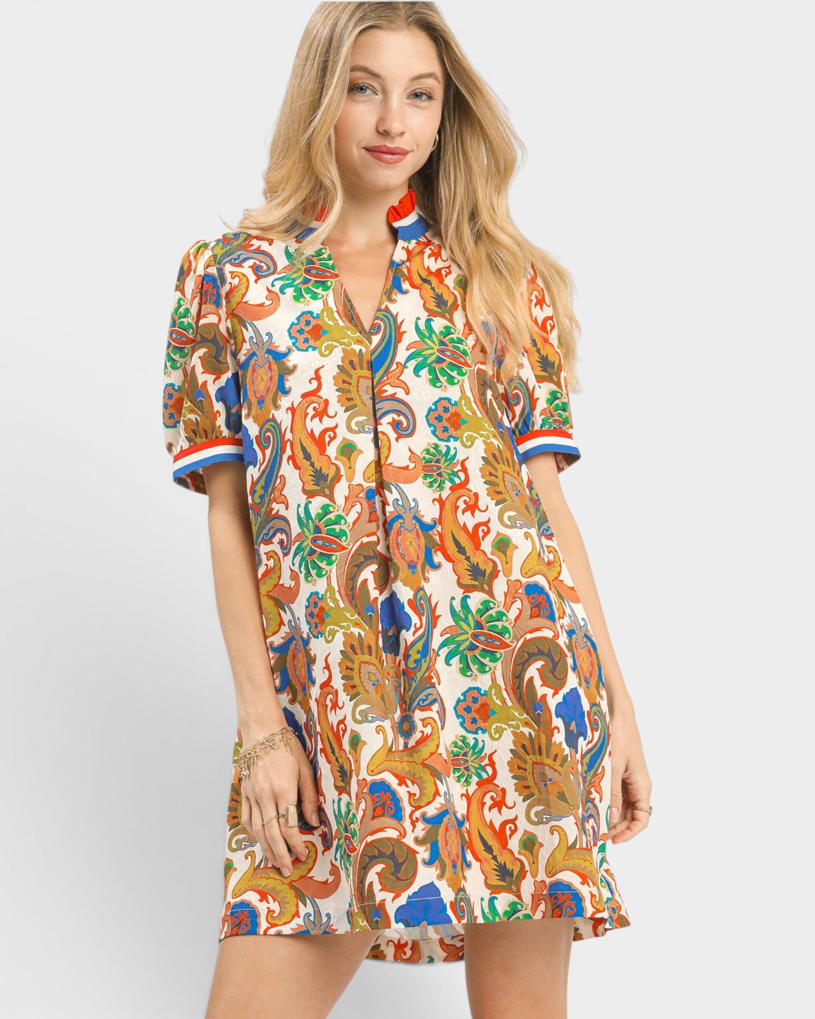 Woman wearing a colorful patterned dress on a white background