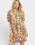 Woman wearing a colorful patterned dress on a white background
