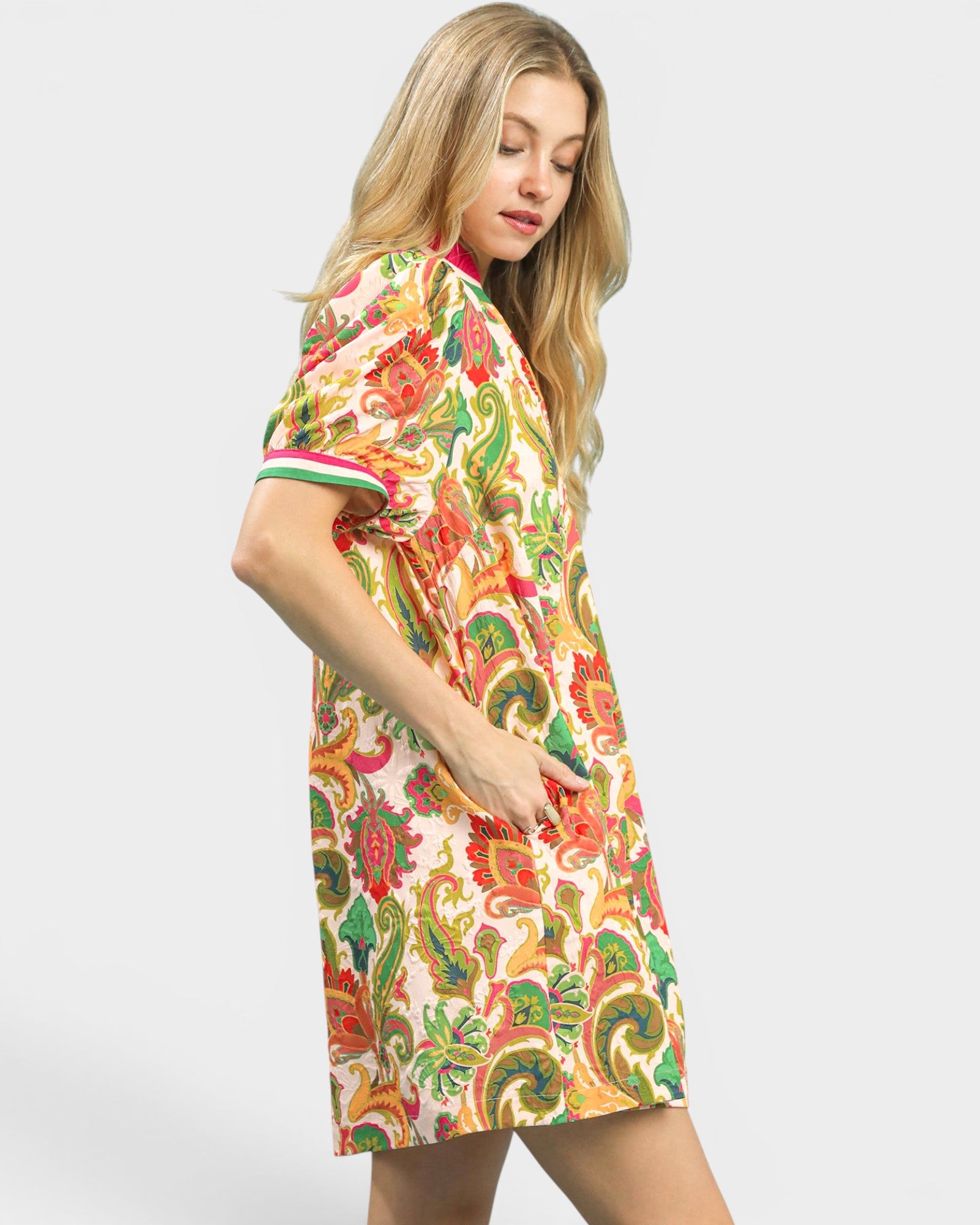 Woman wearing a colorful patterned dress on a white background