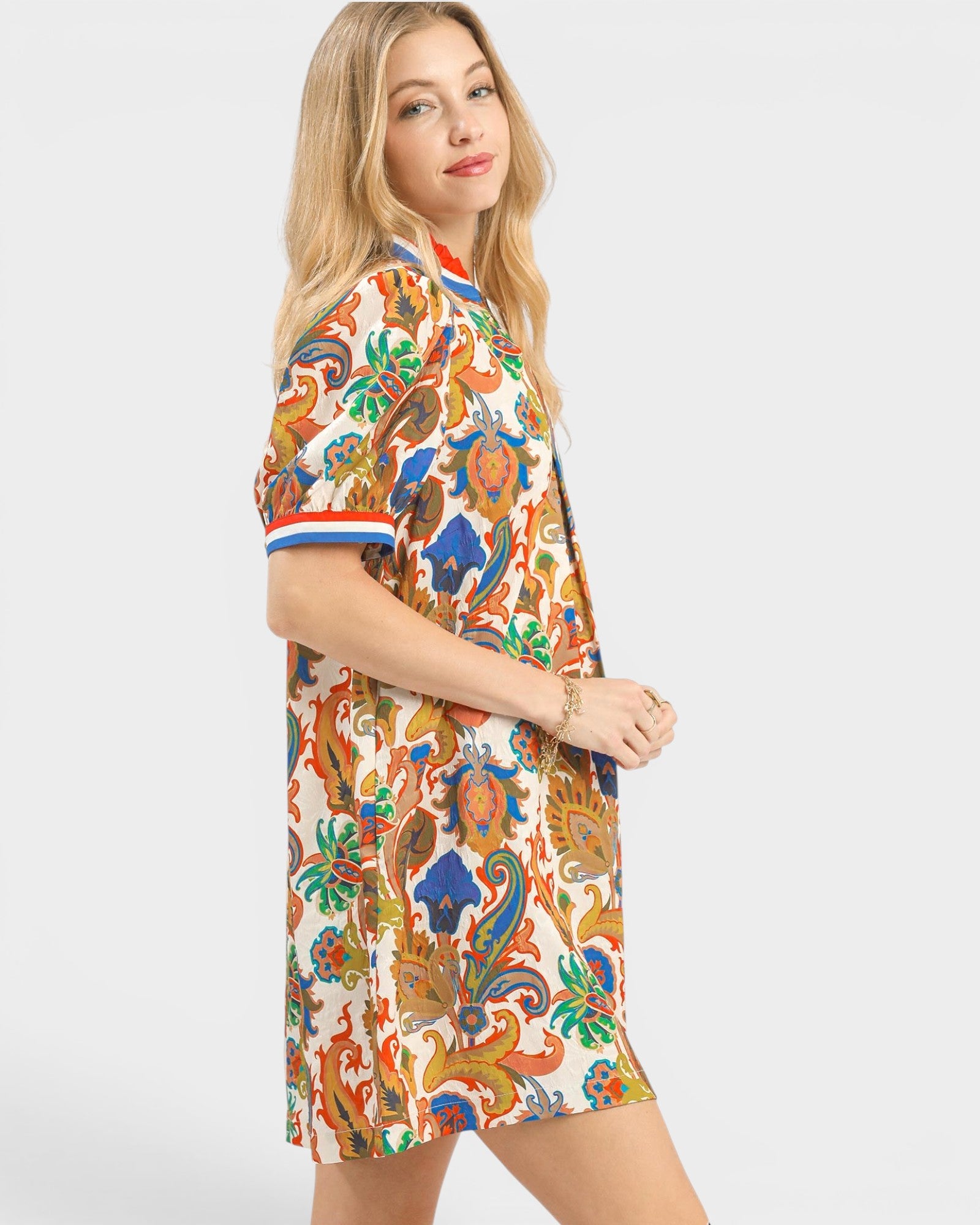 Woman wearing a colorful patterned dress on a white background
