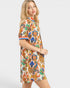 Woman wearing a colorful patterned dress on a white background
