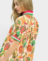 Woman wearing a colorful patterned kimono-style garment on a white background