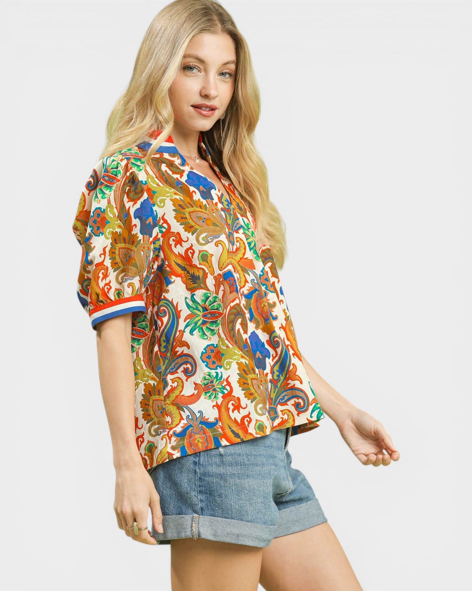 Woman wearing a colorful patterned shirt with a plain background