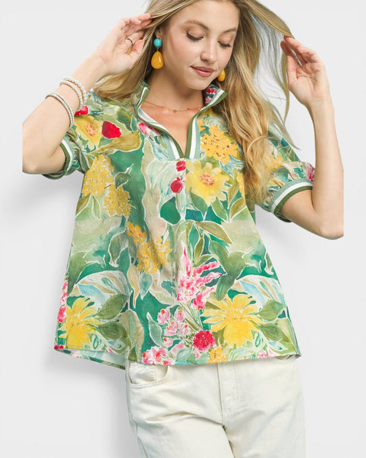 Woman wearing a colorful floral blouse against a white background