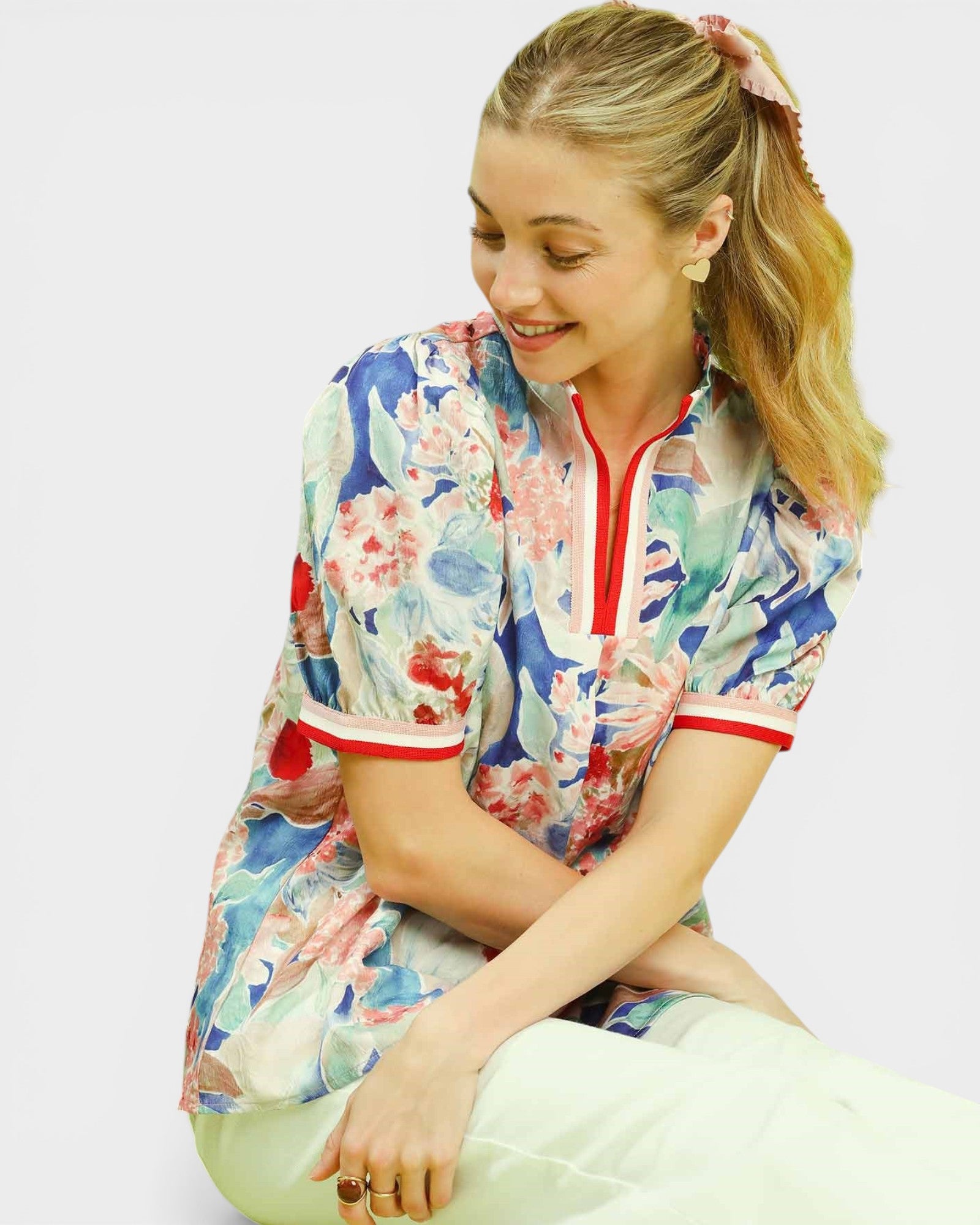 Woman wearing a colorful floral shirt with a white background