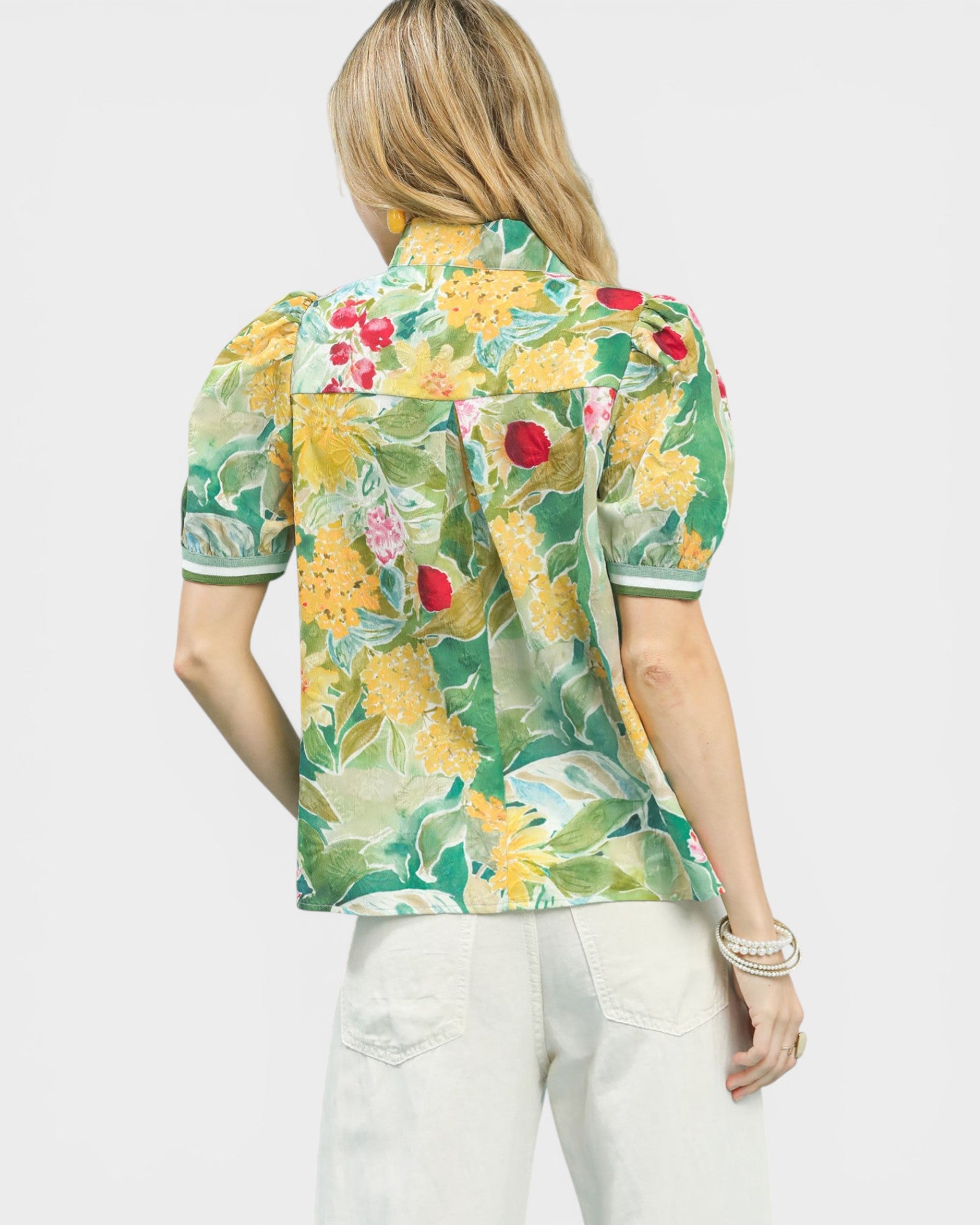 Woman wearing a colorful floral blouse with a white background