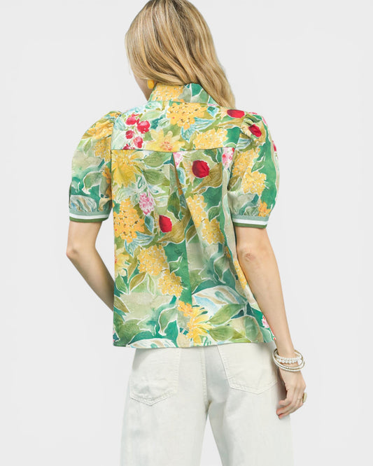 Woman wearing a colorful floral blouse with a white background