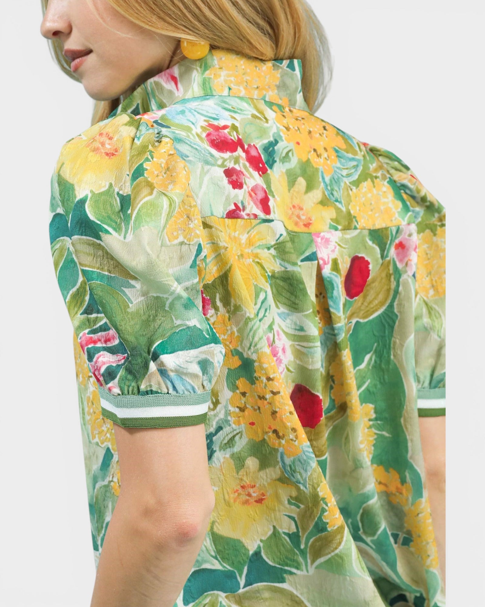 Woman wearing a colorful floral jacket on a white background