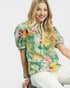 Woman wearing a colorful floral blouse with a white background
