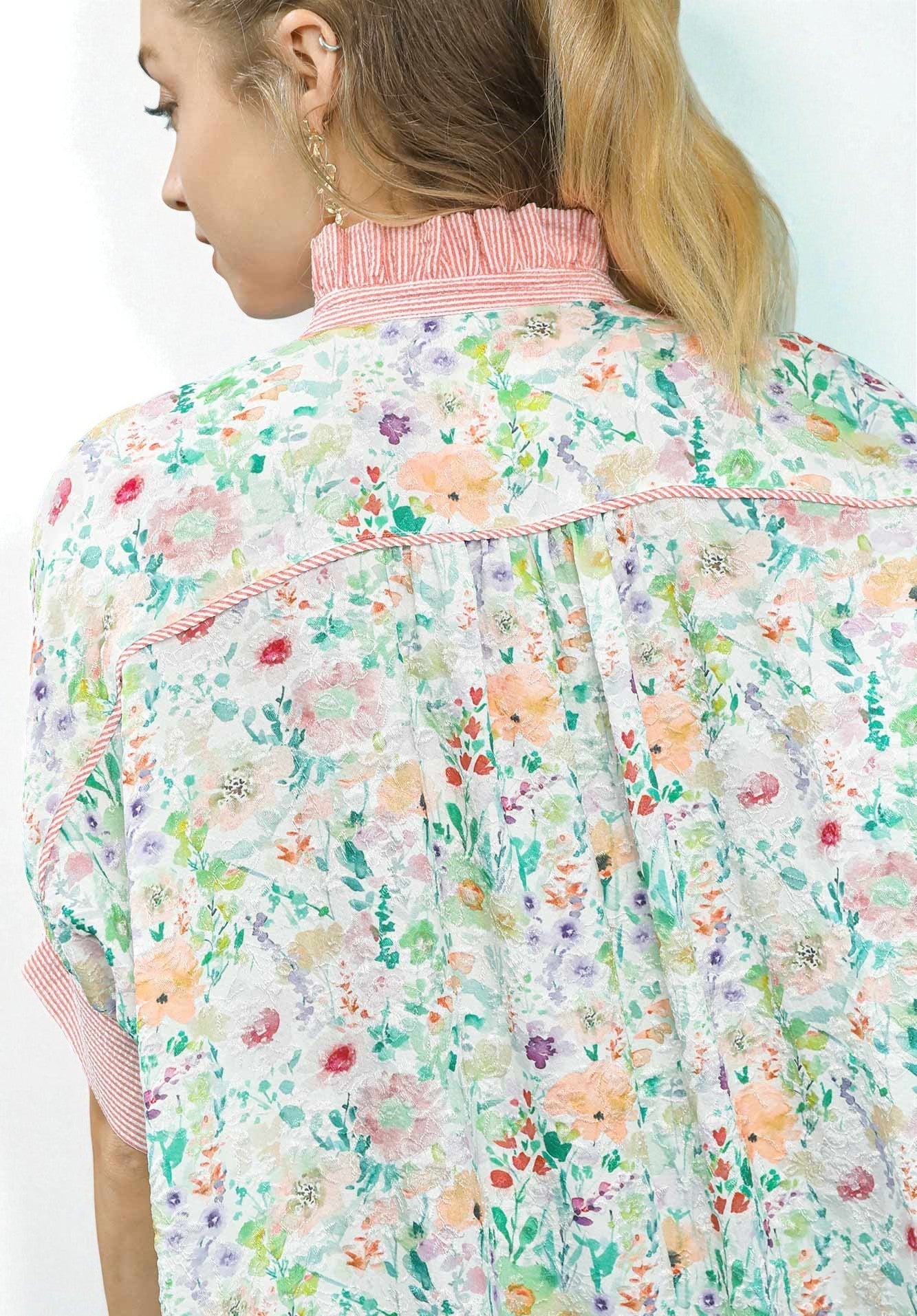 Floral patterned shirt with pink trim on a white background