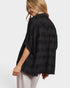 Woman wearing a black patterned shirt on a white background