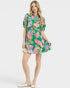 Woman wearing a colorful floral dress on a white background