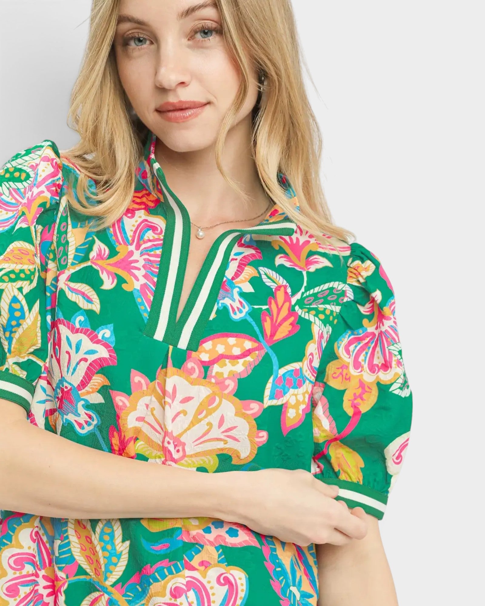 Woman wearing a colorful floral patterned shirt on a white background