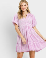 Woman wearing a pink dress with a white background