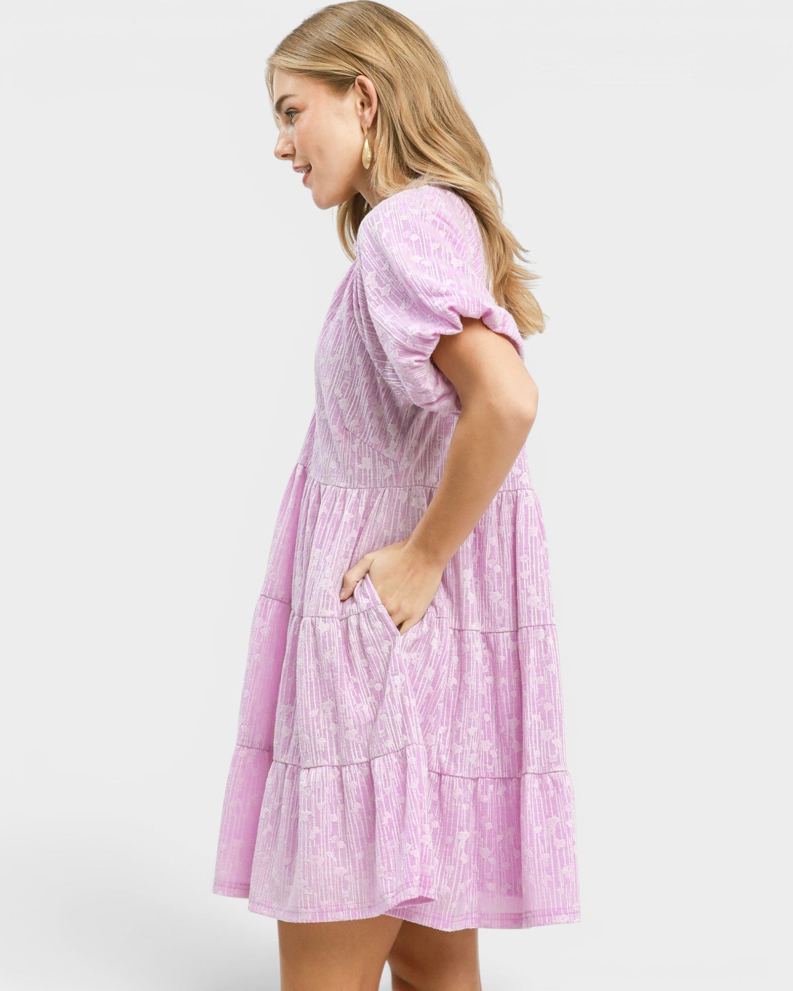 Woman wearing a pink dress with a white background
