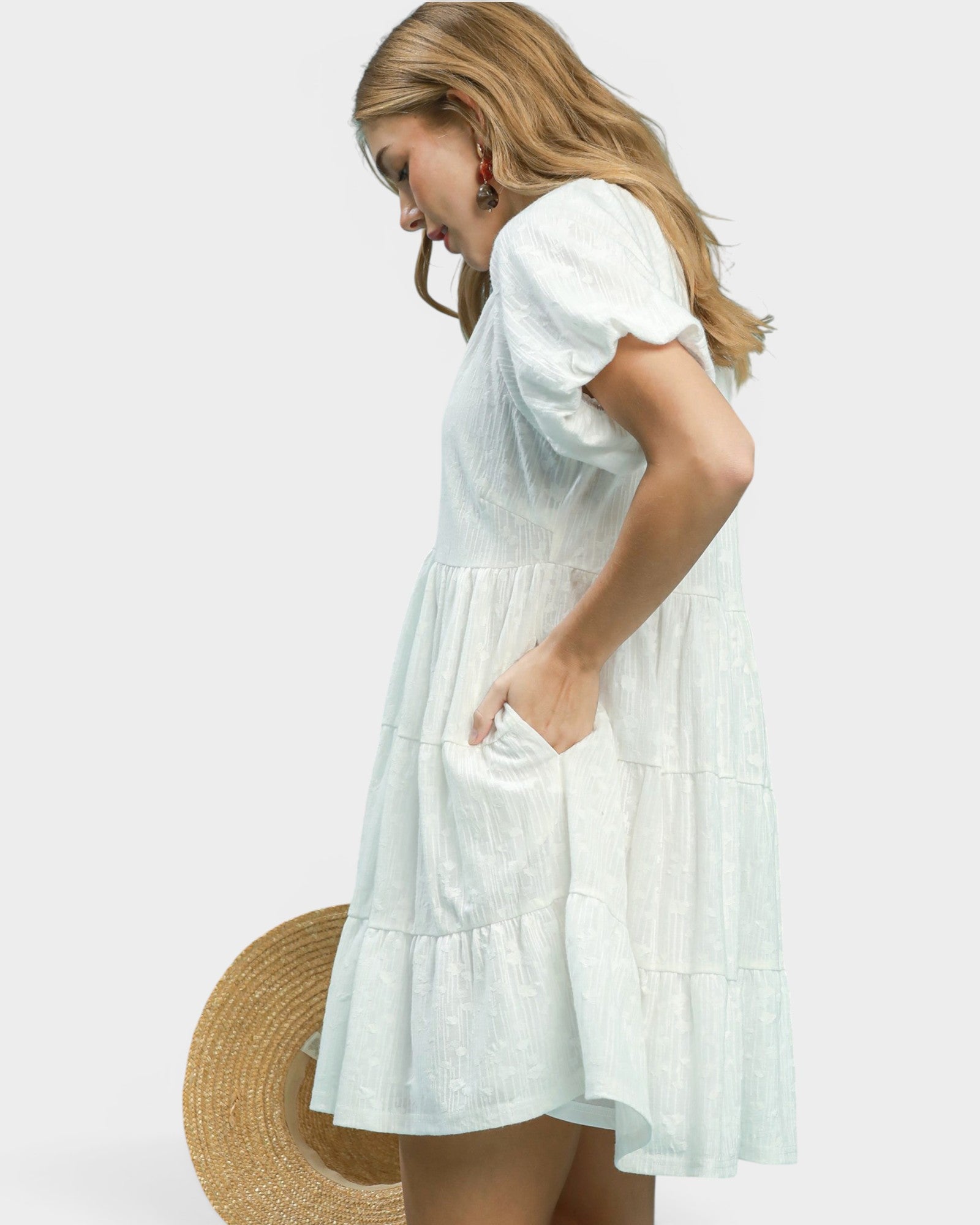 Woman wearing a white dress with a plain background