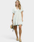 Woman wearing a white dress holding a hat on a white background