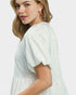 Woman wearing a white dress with a plain background